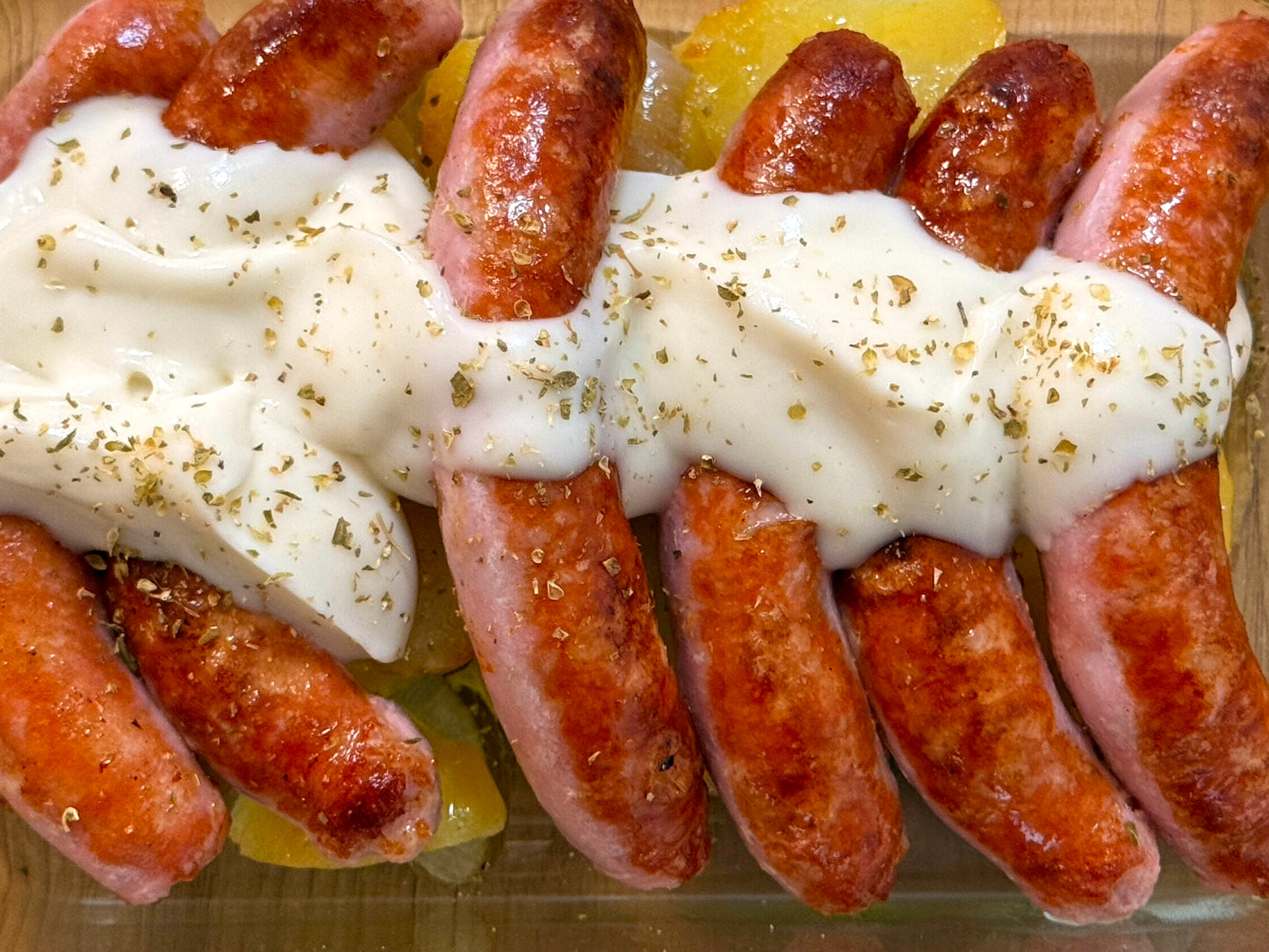 Salchichas de pollo con salsa de queso y patata panadera