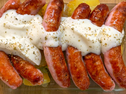 Salchichas de pollo con salsa de queso y patata panadera