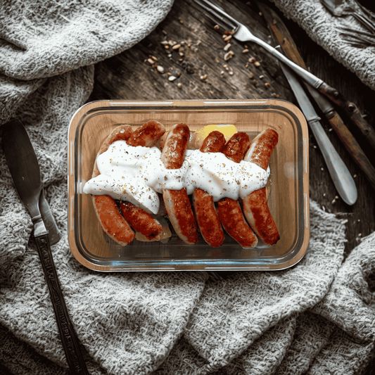 Salchichas de pollo con salsa de queso y patata panadera